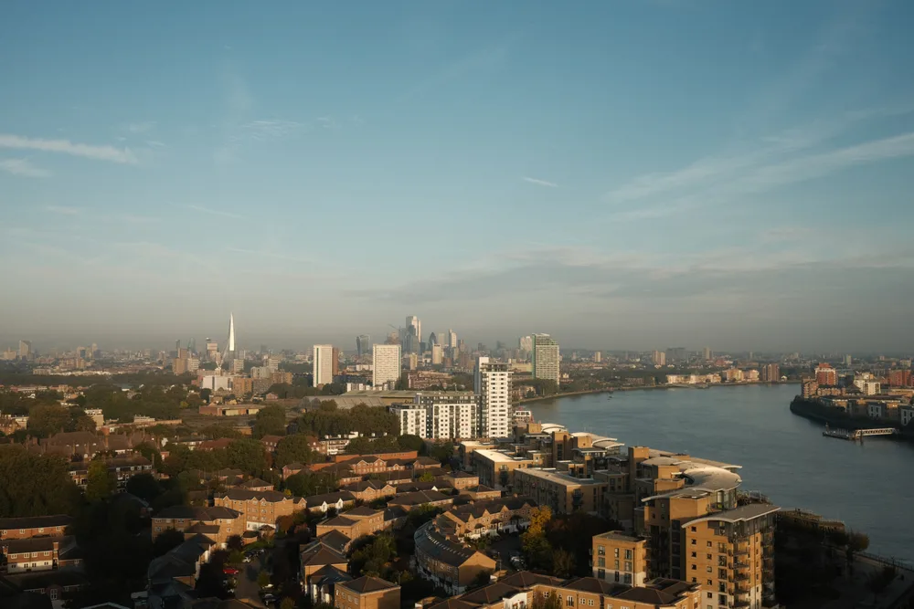 A panorama of London with a bend in the Thames, residential buildings and distant skyscrapers